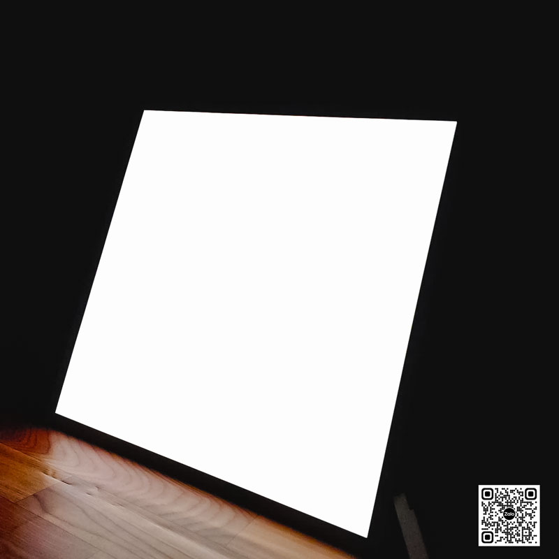 Tấm bảng đèn LED vuông phát sáng đặt trên sàn gỗ trong phòng tối